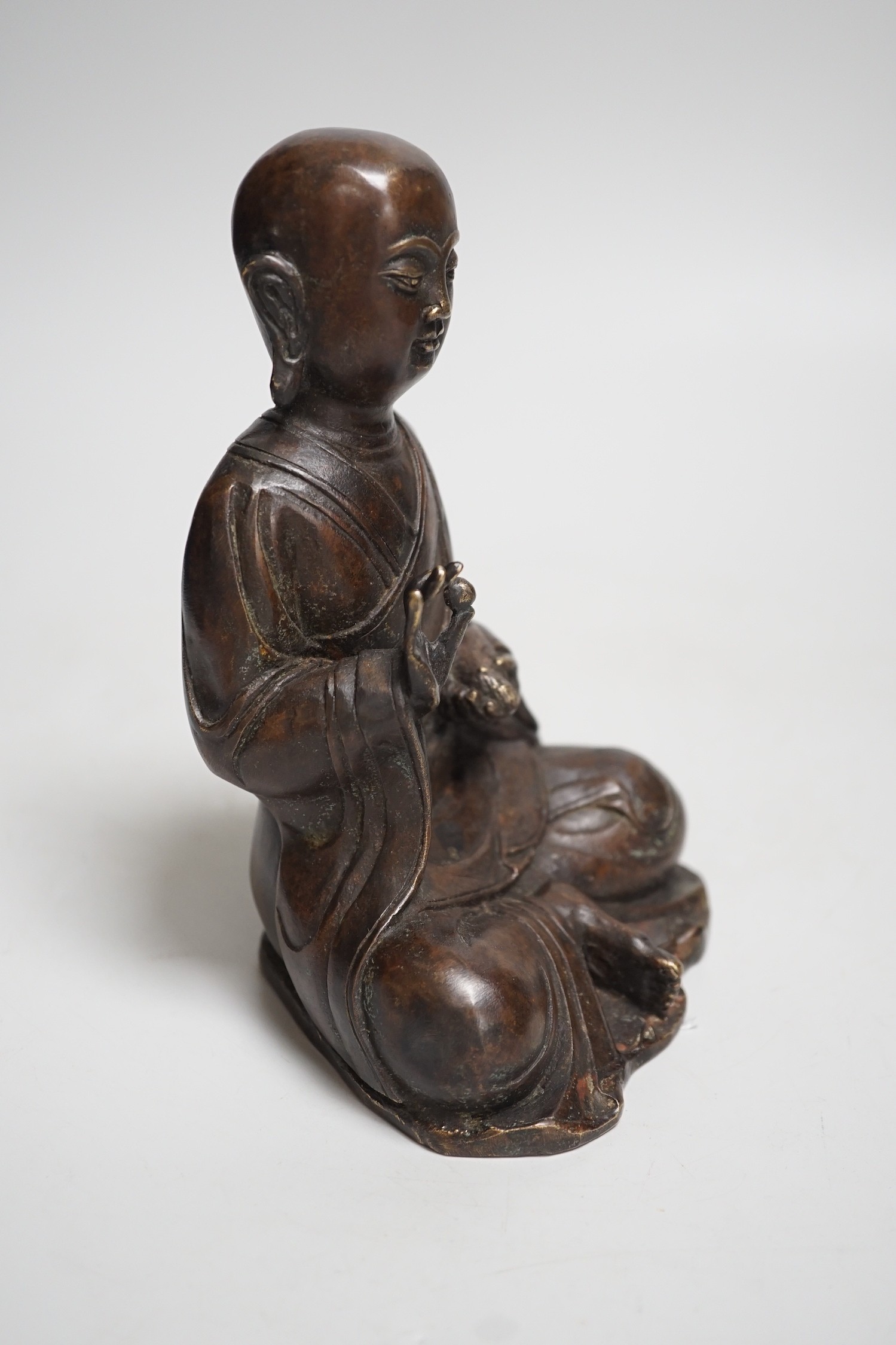 A Nepalese bronze figure of a seated immortal, probably 17th / 18th century, 16cm